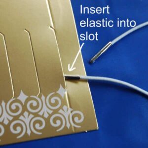The metal end of the elastic goes into the slot